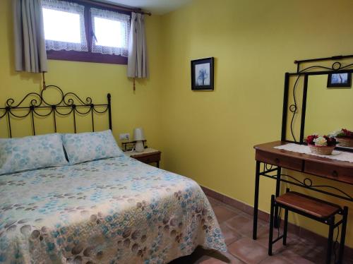 ein Schlafzimmer mit einem Bett und einem Holztisch in der Unterkunft Apartamento Rural in Cangas de Onís