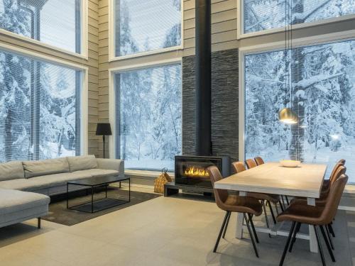 a living room with a fireplace and a table and chairs at Holiday Home Levin hiihtäjä by Interhome in Sirkka