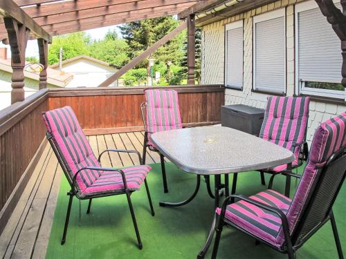 un patio con mesa y sillas en una terraza en Holiday Home Aurora-2 by Interhome en Kurort Steinbach-Hallenberg