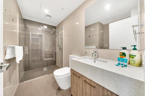 a bathroom with a sink and a toilet and a shower at Vision Apartments On Morphett with Parking in Adelaide