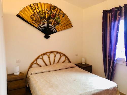 1 dormitorio con 1 cama y ventilador en la pared en Residenze Zodiaco, en Santa Teresa Gallura