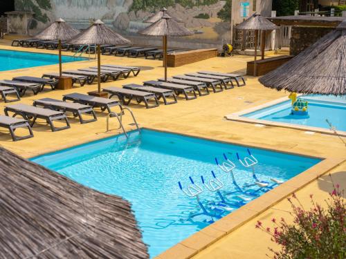 une piscine avec chaises longues et parasols dans l'établissement Holiday Home Prestige Plus 3 chambres by Interhome, à Cendras