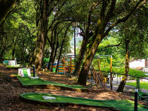 un parc avec une aire de jeux avec des arbres et des toboggans dans l'établissement Holiday Home Prestige Plus 3 chambres by Interhome, à Cendras