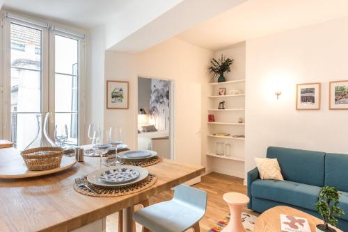 un salon avec une table et un canapé bleu dans l'établissement Charming flat - 4 guests - Saint-Germain des pres, à Paris