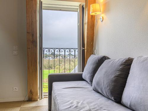 - un canapé dans le salon doté d'une grande fenêtre dans l'établissement Apartment Château De Kergonano-20 by Interhome, à Baden