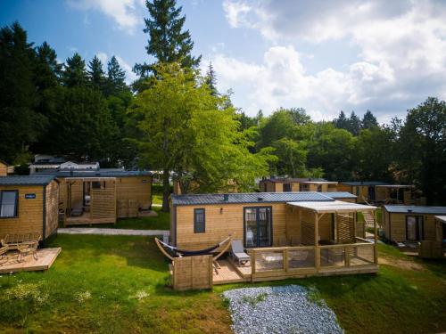 un groupe de petites maisons dans les bois dans l'établissement Holiday Home Luxe 3 chambres 6 personnes by Interhome, à Payrac