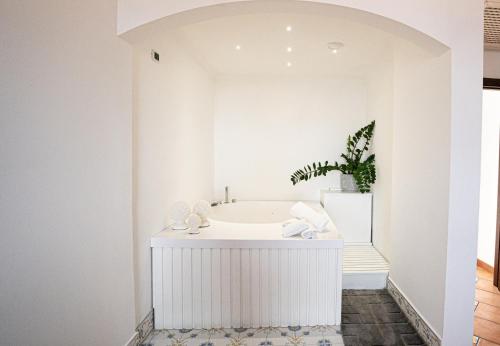 Habitación con baño blanco con bañera. en Villa Palmentiello, en SantʼAntonio Abate