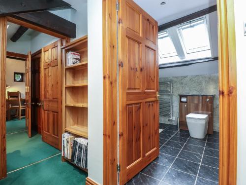 La salle de bains est pourvue de placards en bois et de toilettes. dans l'établissement The Gardener's Bothy, à Penrith