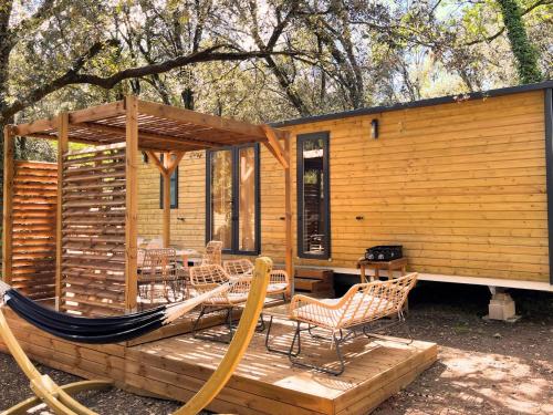 une cabine avec un hamac et des chaises sur une terrasse dans l'établissement Holiday Home Lodge Luxe 3 chambres by Interhome, à Cendras