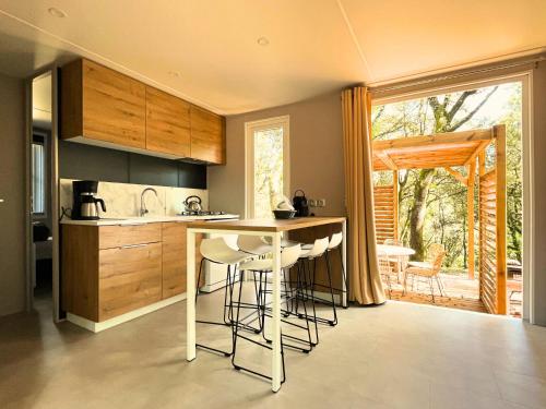 une cuisine avec un îlot et des tabourets de bar dans l'établissement Holiday Home Lodge Luxe 3 chambres by Interhome, à Cendras