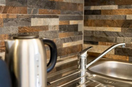a kitchen counter with a sink and a faucet at Cosy Countryside retreat - Woody in Milton Keynes