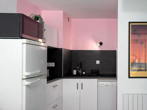 - une cuisine avec des murs roses et noirs et un réfrigérateur dans l'établissement Apartment East Land-3 by Interhome, à La Grande Motte