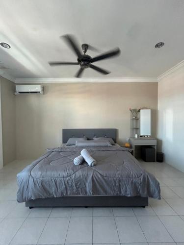 1 dormitorio con 1 cama y ventilador de techo en H&N Airbnb en Miri