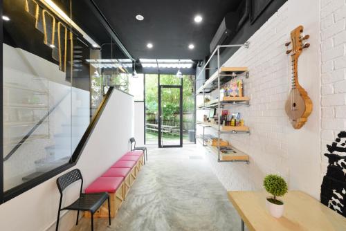 a room with a bench and a guitar on the wall at The Cube Hostel Silom in Bangkok