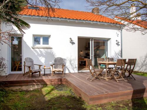 une terrasse en bois avec des chaises et une table en face d'une maison dans l'établissement Holiday Home Ty Gwen by Interhome, à Pornic