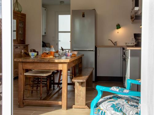 Holiday Home Ty Gwen by Interhome في بورنيك: مطبخ مع طاولة خشبية وثلاجة