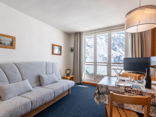 un salon avec un canapé et une table avec une télévision dans l'établissement Studio résidence Le Lac - Le lac by Interhome, à Tignes