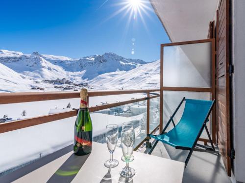 - une bouteille de vin et des verres sur un balcon avec des montagnes enneigées dans l'établissement Studio résidence Le Lac - Le lac by Interhome, à Tignes