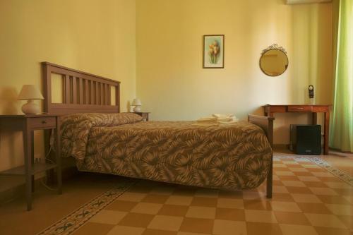 a bedroom with a bed and a table and a mirror at B&B Palazzo Corvino in Palermo