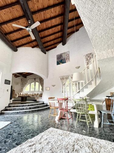 - un salon avec un ventilateur de plafond et des chaises dans l'établissement Villa charmante à Porto-Vecchio avec vue sur la montagne., à Porto-Vecchio