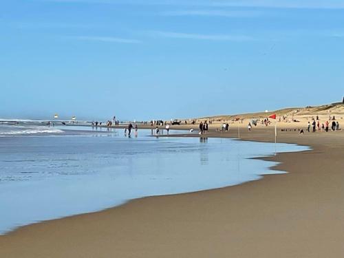 a group of people walking on a beach at Apartment L'Oustalet-6 by Interhome in Mimizan