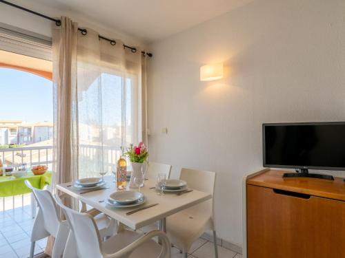 une salle à manger avec une table avec des chaises et une télévision dans l'établissement Apartment Primavera-3 by Interhome, au Cap d'Agde