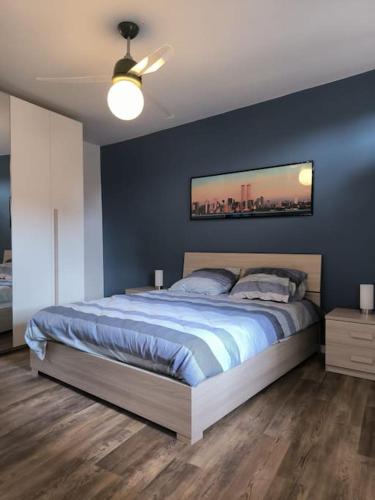 ein Schlafzimmer mit einem großen Bett mit blauer Wand in der Unterkunft Appartamento - Centro Storico in Savigliano