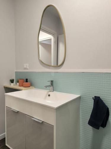 ein Badezimmer mit einem weißen Waschbecken und einem Spiegel in der Unterkunft Appartamento - Centro Storico in Savigliano