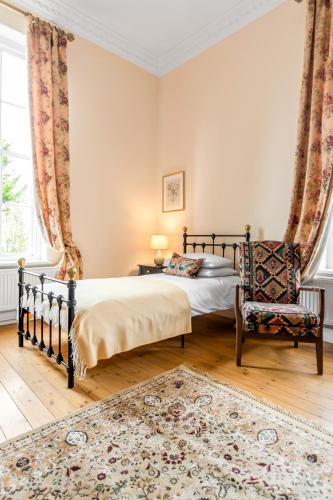 a bedroom with a bed and a chair at Must see - Georgian Mansion I Suffolk Retreat in Beccles