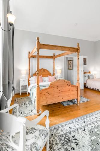 a bedroom with a wooden bed and a chair at Must see - Georgian Mansion I Suffolk Retreat in Beccles