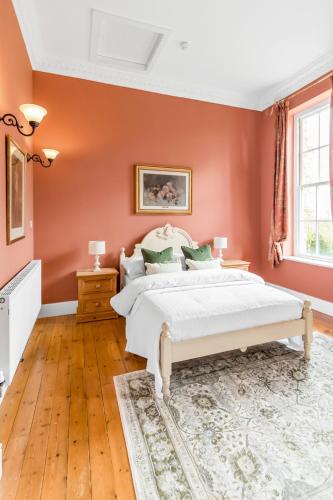 a bedroom with orange walls and a large bed at Must see - Georgian Mansion I Suffolk Retreat in Beccles