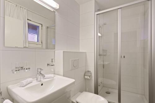 a white bathroom with a sink and a shower at Fantastic 2 bedroom flat close to the lake (Mainau 4) in Zürich