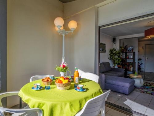 une table avec un chiffon de table jaune et des fruits dessus dans l'établissement Apartment Le Sunset-Cap Sud-24 by Interhome, au Cap d'Agde