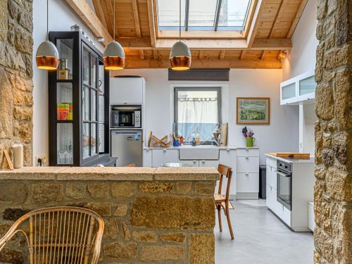 - une cuisine avec des placards blancs et un mur en pierre dans l'établissement Holiday Home Maison Maison Ty Mad by Interhome, à Belz