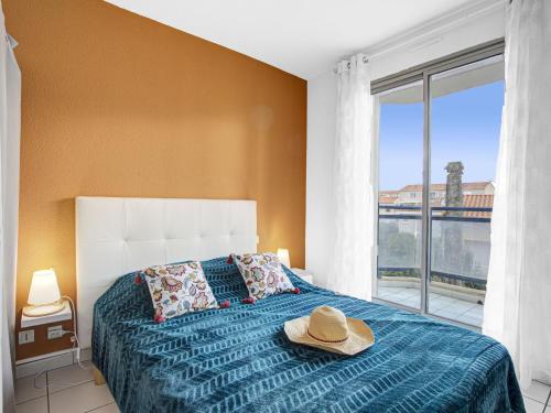 una camera da letto con un letto con un cappello sopra di Apartment Central Park by Interhome a Canet-en-Roussillon