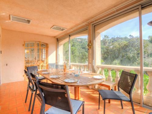 une salle à manger avec une table et des chaises et une grande fenêtre dans l'établissement Villa Cap Roux by Interhome, à Agay