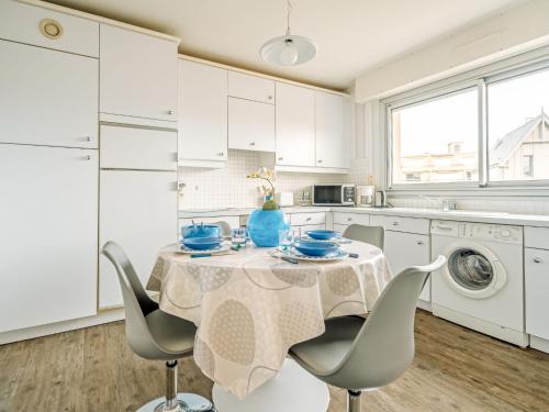 - une cuisine blanche avec une table et des chaises ainsi qu'un lave-linge dans l'établissement Apartment Ker Enclos 3 by Interhome, à Dinard