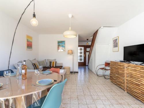 un salon avec une table et une télévision dans l'établissement Holiday Home Les Iris by Interhome, à Carqueiranne