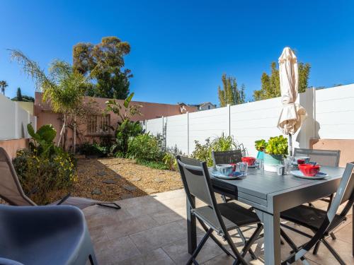 une terrasse avec une table, des chaises et un parasol dans l'établissement Holiday Home Les Iris by Interhome, à Carqueiranne