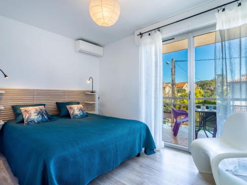 une chambre avec un lit bleu et un balcon dans l'établissement Holiday Home Les Iris by Interhome, à Carqueiranne