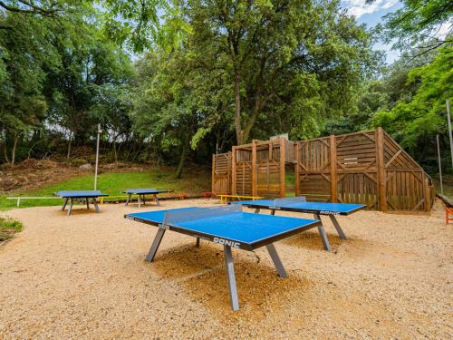 3 tables de ping-pong devant une aire de jeux dans l'établissement Holiday Home La Clémentine Chalet Confort 4-5 pers by Interhome, à Cendras