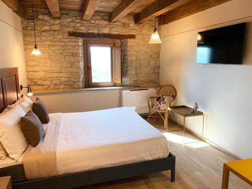 1 dormitorio con cama, ventana y silla en Ca' Nobili - Charming Country House en Vetto
