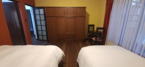 a bedroom with two beds and a dresser and a cabinet at Raven La Paz in La Paz