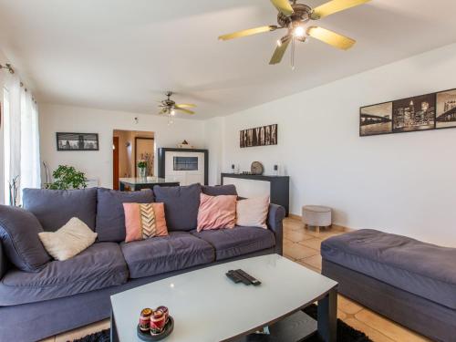 Una sala de estar con un sofá azul y una mesa. en Holiday Home Océane by Interhome, en Saint-Martin-de-Seignanx
