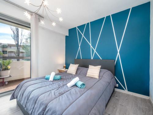une chambre avec un grand lit aux murs bleus dans l'établissement Apartment Les cyclades by Interhome, à Antibes
