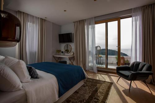 a bedroom with a bed and a chair and a window at Dubrovnik luxury apartments in Dubrovnik