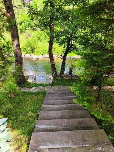 a stone path next to a river with trees at Luxury Resort Riverfront with Pool&Sports in Višegrad