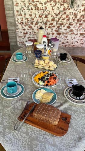 a table with plates of food on top of it at Casa Cacau Boutique B&B - Sítio Salamandra Vale do Matutu in Aiuruoca