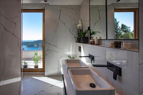La salle de bains est pourvue d'un lavabo et d'un grand miroir. dans l'établissement Dubrovnik luxury apartments, à Dubrovnik