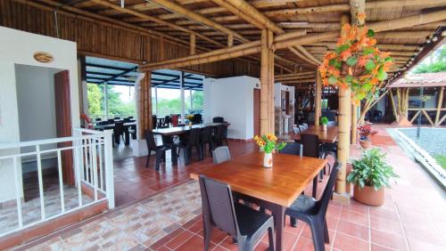 uma sala de jantar com uma mesa de madeira e cadeiras em Finca Hotel La Linda em Quimbaya